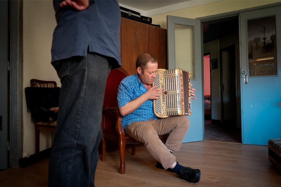 Un homme qui joue de l'accordéon dans une maison