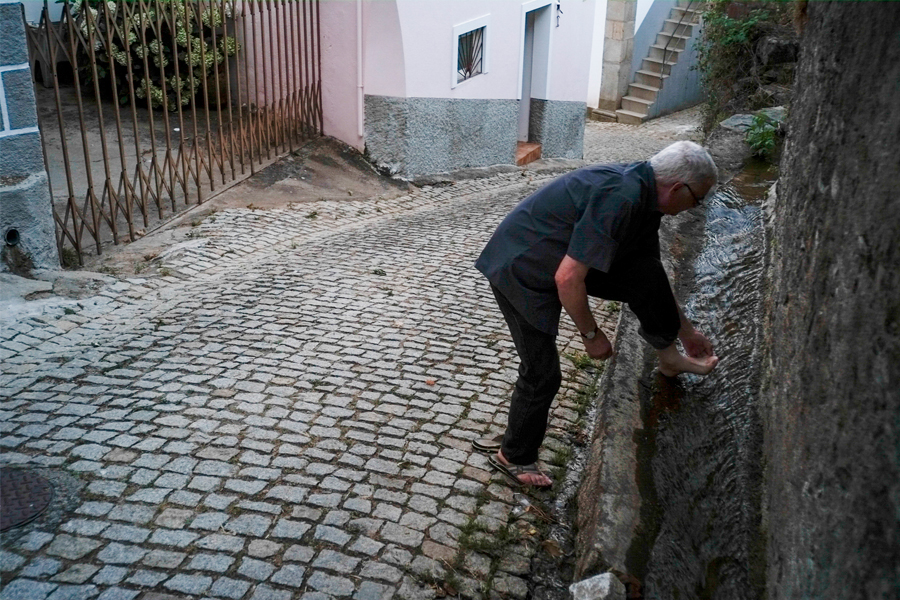 Homme qui se lave les pieds dans la rue