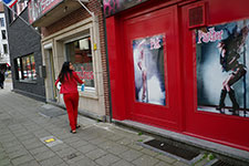 Passante asiatique devant des affiches de mannequins