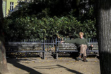 Homme assis sur un banc avec une bouteille à la main