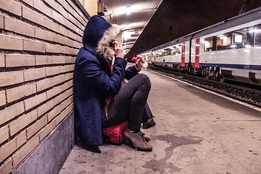 Jeune fille assise qui attend le train