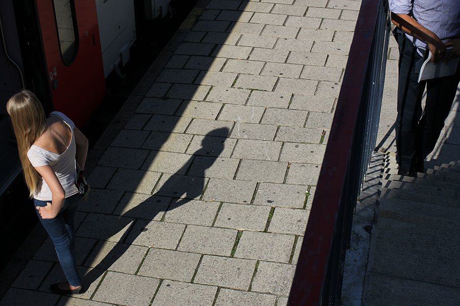 Jeune fille et son ombre près d'un train