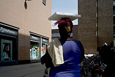 Femme africaine portant une boîte de pizza sur sa tête