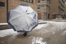 Homme portant un parasol avec de la neige dessus