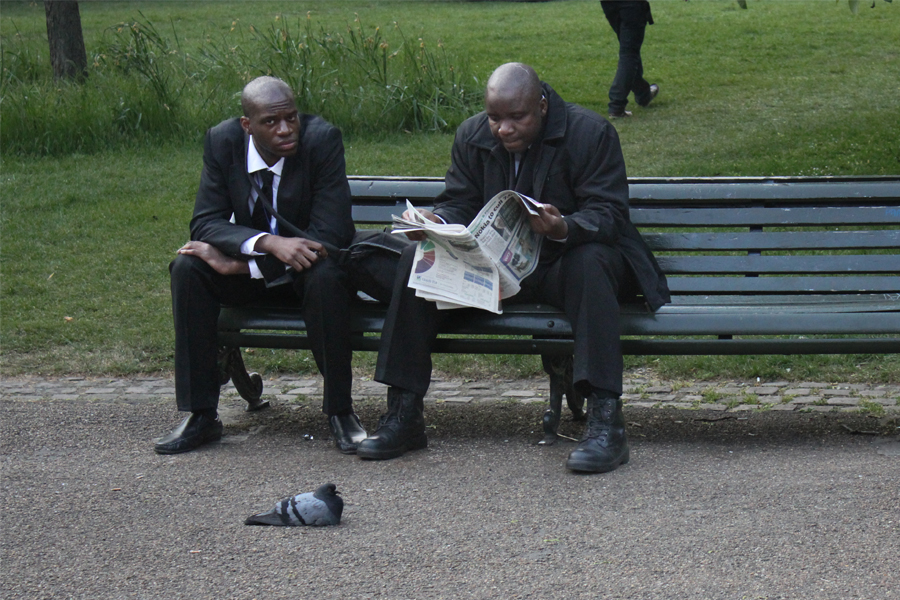 Deux hommes noirs assis sur un banc public