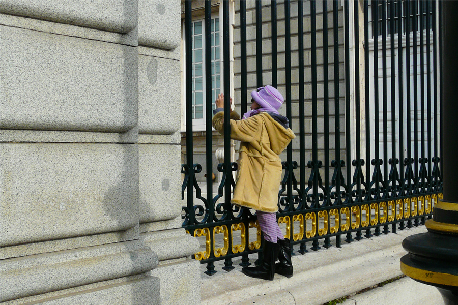 Petite fille tenue à des barreaux