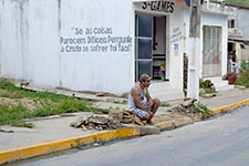 Homme accroupie dans la rue